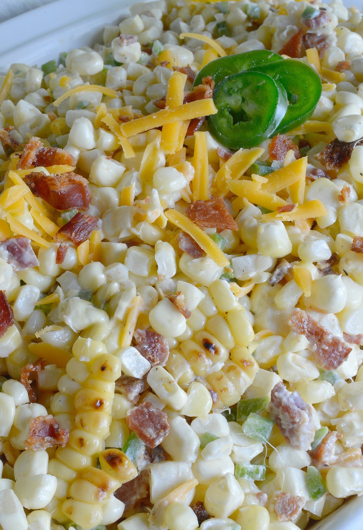 Bring on Summer and Barbecue season! This Jalapeño Popper Grilled Corn Salad Recipe brings so many great flavors together in one amazing side dish! Fresh grilled corn, bacon, jalapeño and cheddar cheese in a creamy summer salad.