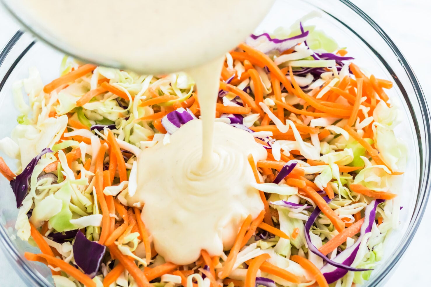 poring dressing over cabbage