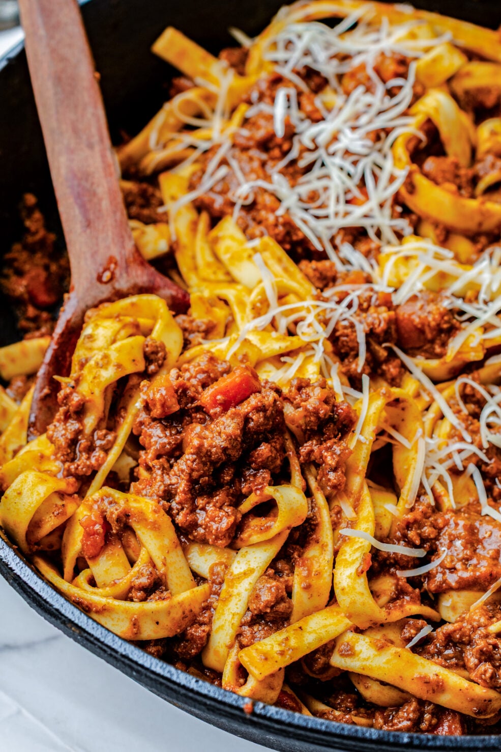 spoon scooping pasta out of pan
