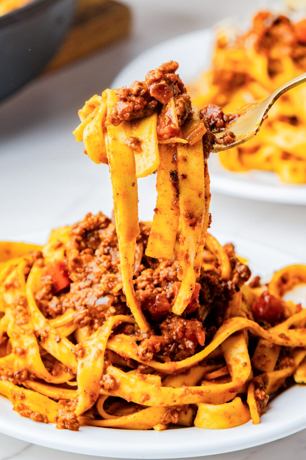 fork scooping bite of pasta from plate